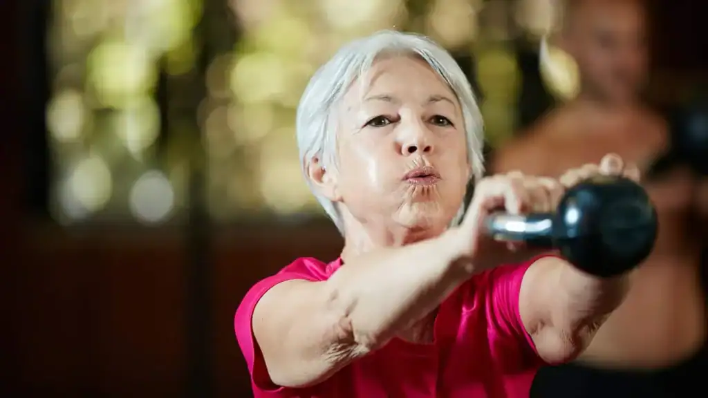 Toning Arms After 60: Empowering Womens Fitness Through Effective Weight Training 1 Older woman doing weight training Wiltshire to help her strength and longevity