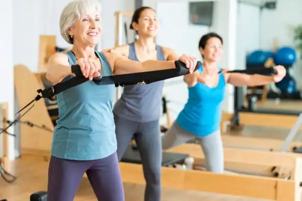 Toning Arms After 60: Empowering Womens Fitness Through Effective Weight Training 2 older woman doing weight training Wiltshire and resistance in the gym to tone upper arms