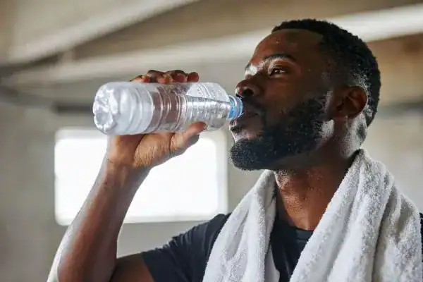 Hydration: The Secret Ingredient for a Toned Stomach and Enhanced Fitness 1 Image of man drinking water to improve hydration Wiltshire after work out.